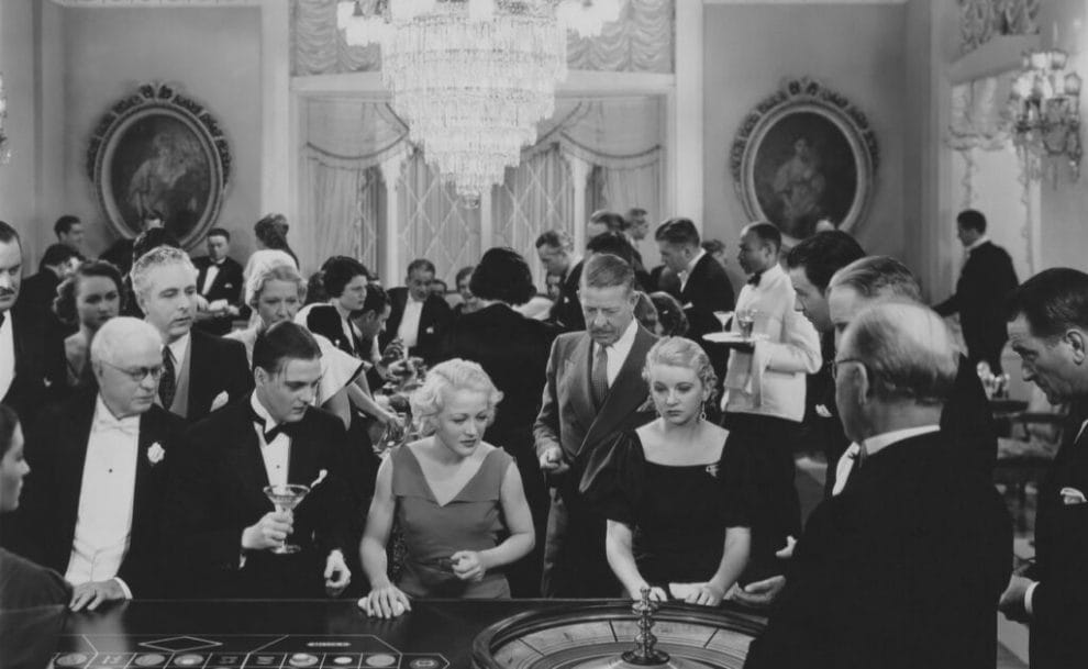 An old black-and-white photo of people around a roulette game.