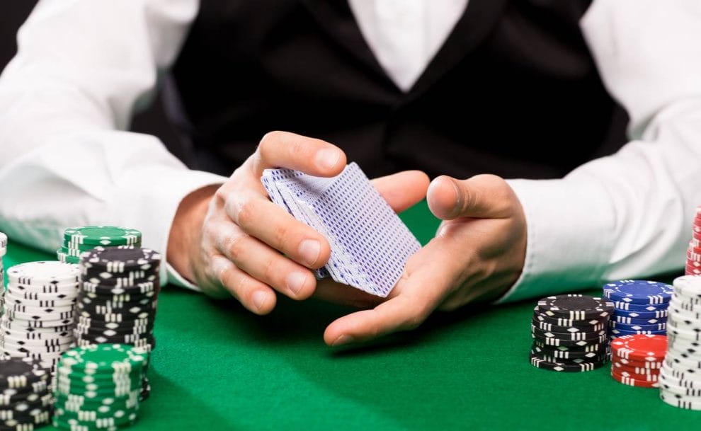 A dealer shuffles a deck of cards.