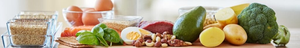 Healthy vegetables and proteins displayed on a wooden counter.