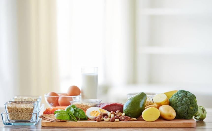 Healthy vegetables and proteins displayed on a wooden counter.
