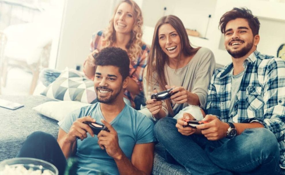 A group of friends holding consoles playing video games.