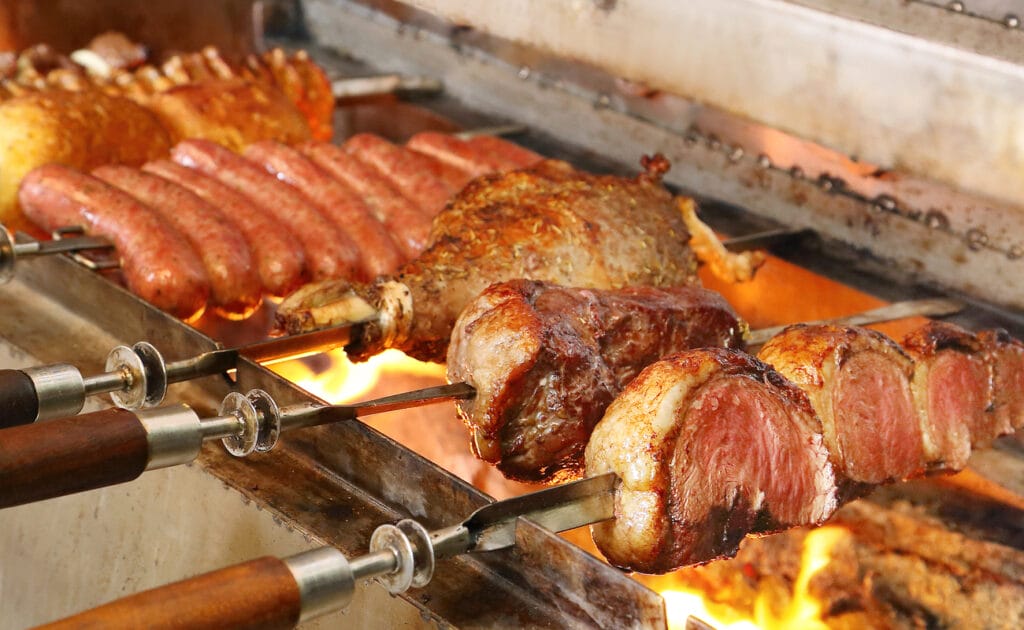 A traditional churrasco with a variety of meats skewered over flames.