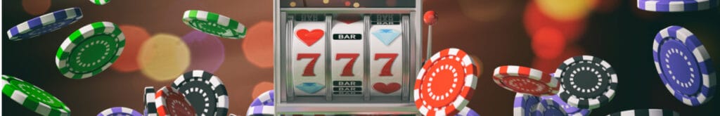 A slots reel on a mobile phone surrounded by casino chips.