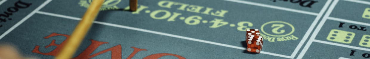 A partial view of a craps table with dice on it.