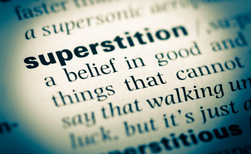 The words superstition highlighted in a dictionary.