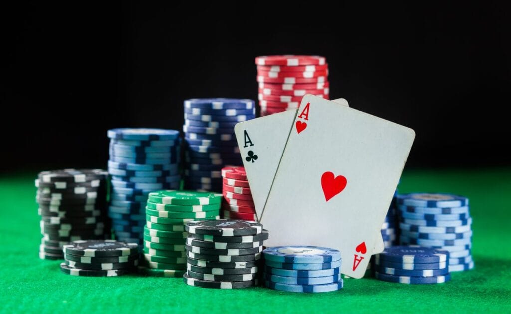 Poker chips and cards on a green felt table.