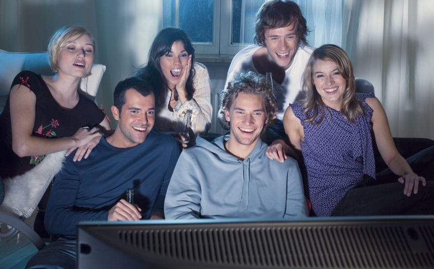 A group of friends watches TV together.