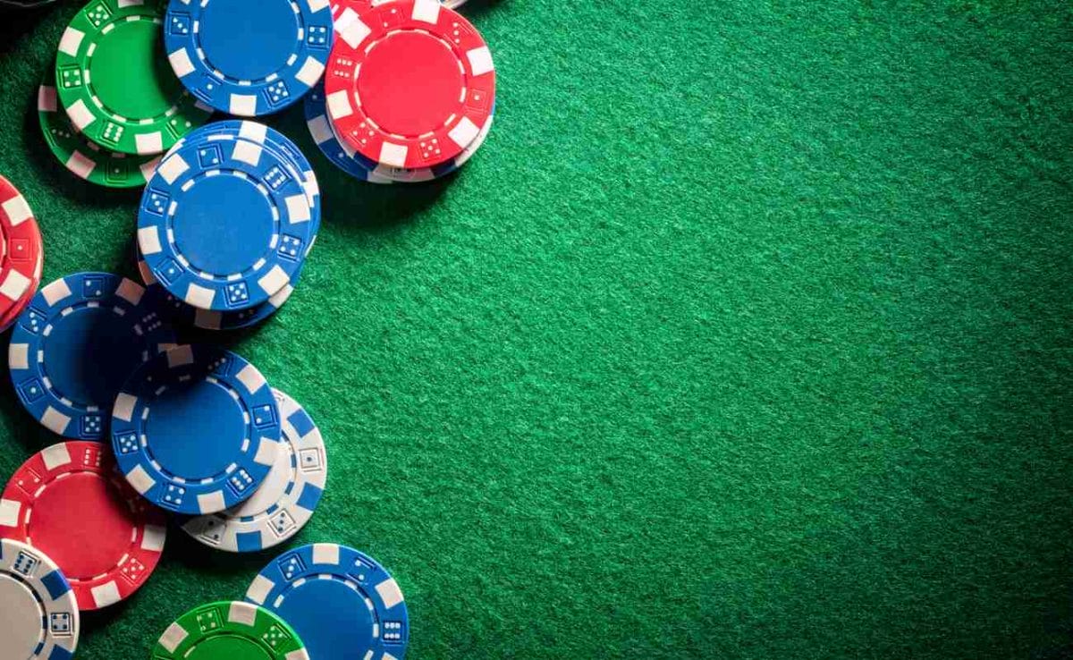 Colorful poker chips on a green felt table.