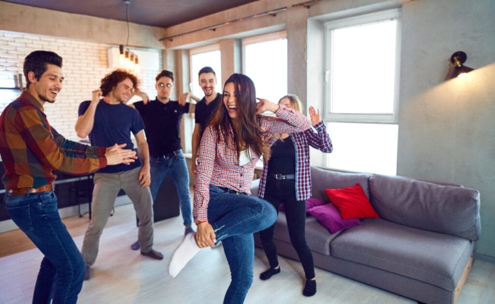 A couple of friends dancing to music in the lounge.