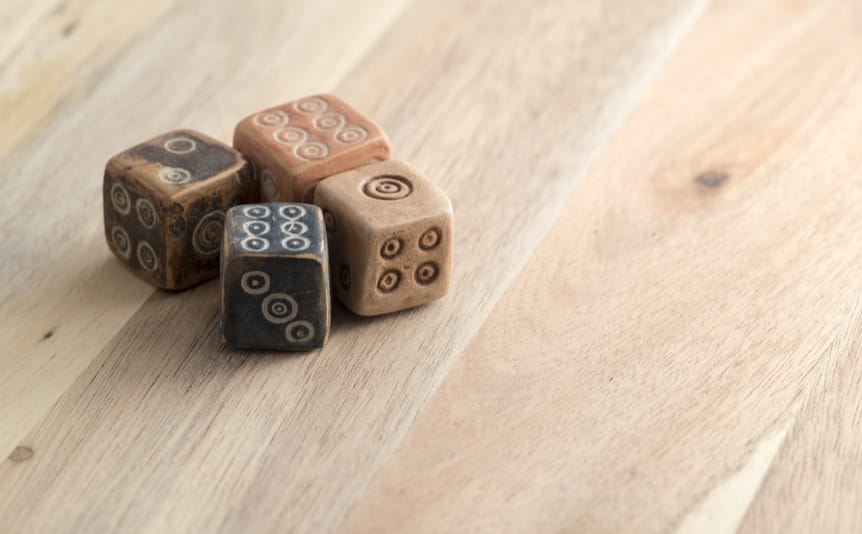 Ancient-looking dice on a wooden table.