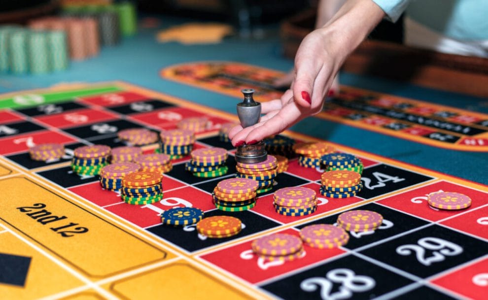 A croupier selects the winning bet on a roulette table.