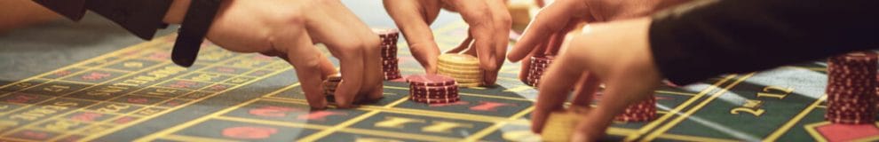 A close-up of people placing chips on a roulette table.