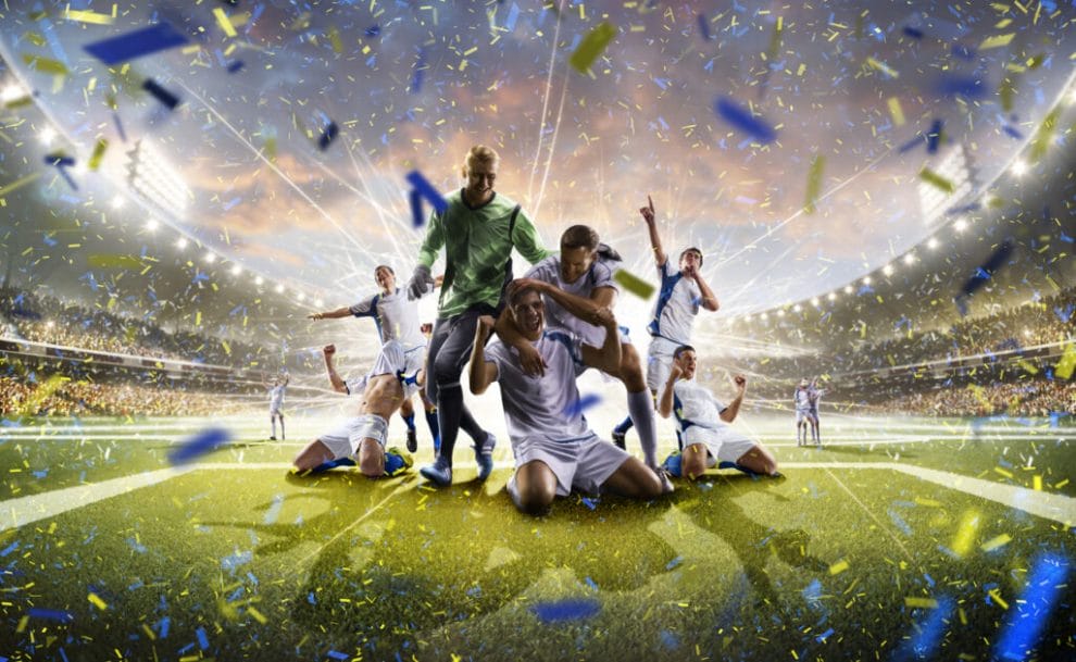 A soccer team celebrates in a stadium with confetti all around.