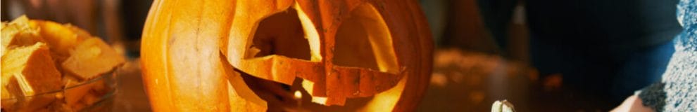 A woman carves a fall pumpkin.