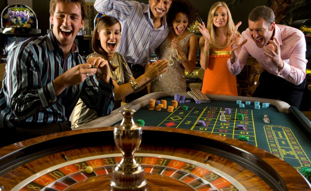 A group of men and women at a casino roulette table.