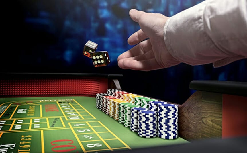 Dice being thrown onto a craps table by a shooter.