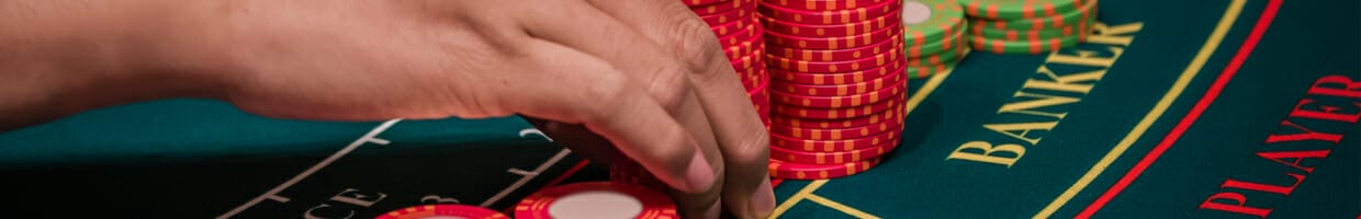 A dealer organizing chips on a baccarat table.