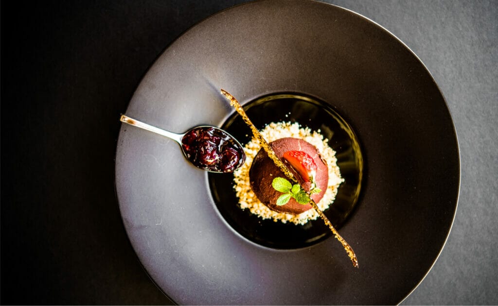 A beautiful and elegant pudding on a black bowl.