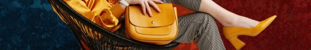 Fashion portrait of an elegant woman wearing yellow shoes and holding a stylish leather bag.