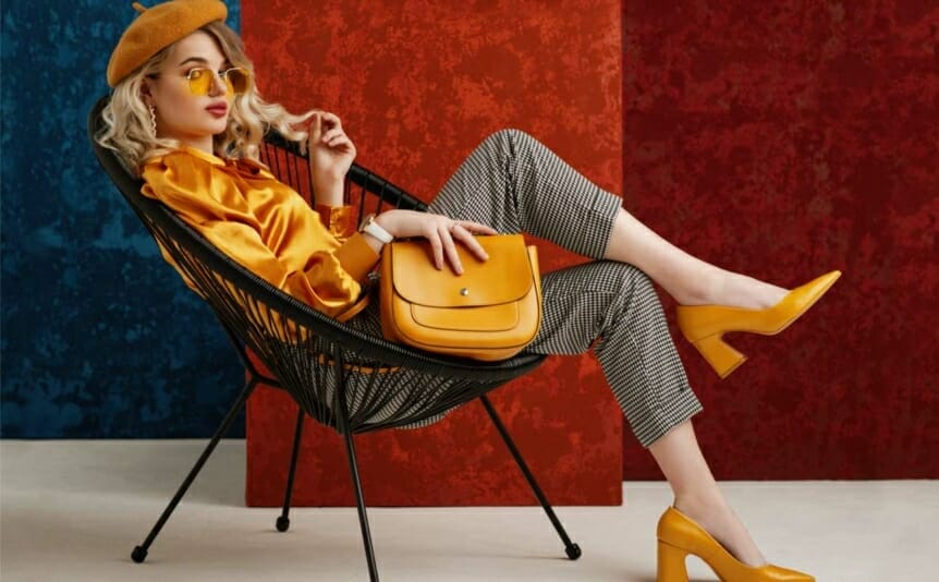 Fashion portrait of an elegant woman wearing yellow shoes and holding a stylish leather bag.