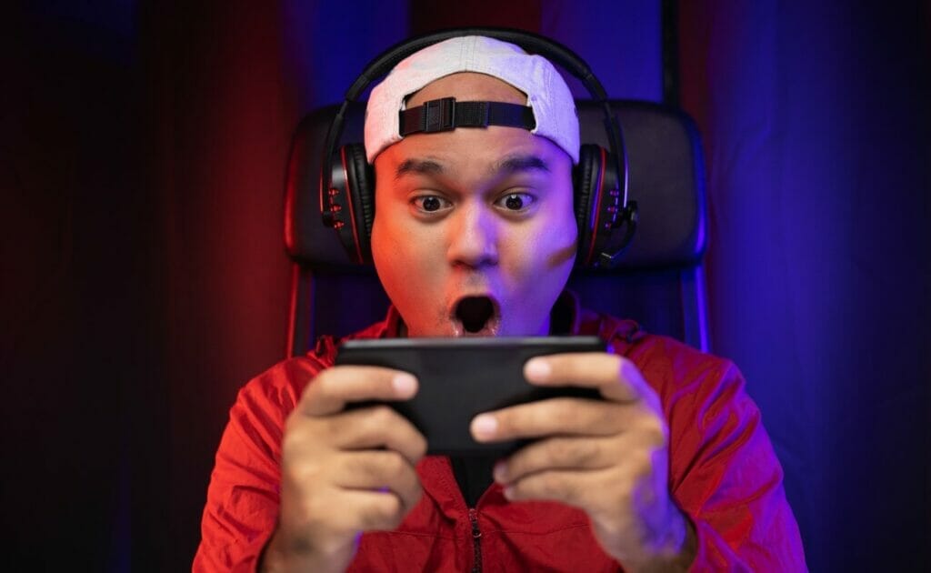 A man is amazed while playing a smartphone game.