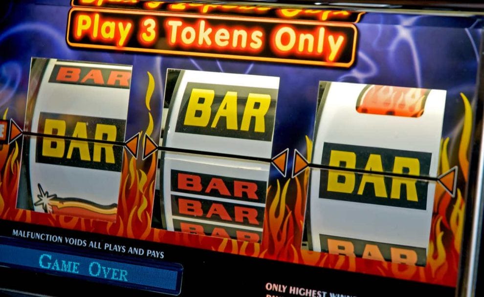 Closeup of a classic slot machine featuring BAR symbols