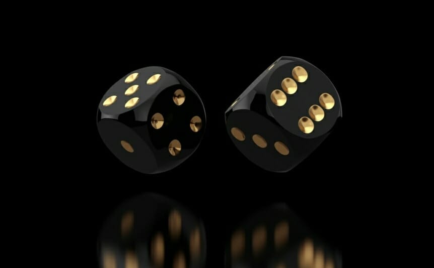 A pair of black and gold dice rolling against a black background
