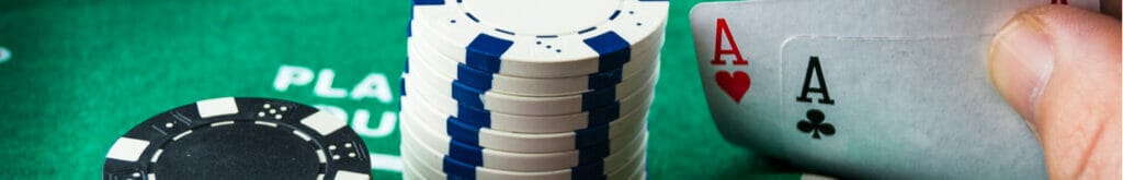 Poker chips and playing cards on a green felt poker table.