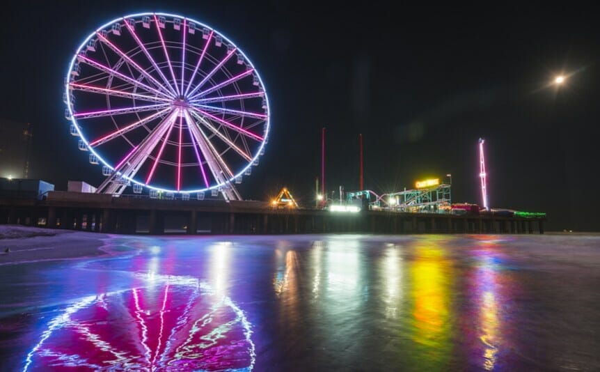 The Steel Pier in Atlantic City, as seen from the beach with the Ferris wheel and amusement park rides.