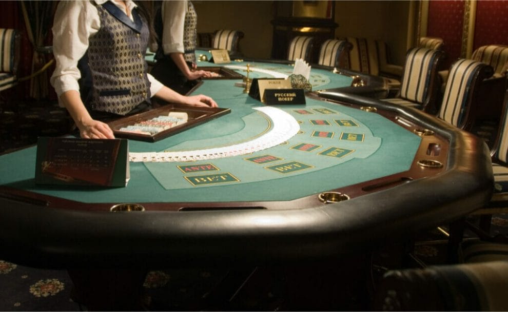 A modern poker table with a dealer waiting for players to arrive.