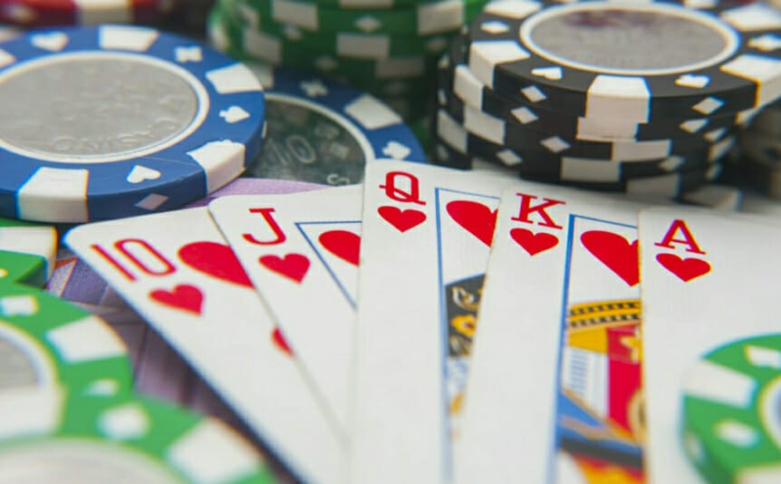 A royal flush sits on top of stacks of poker chips.
