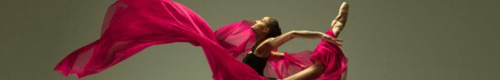 A ballet dancer with a pink silk cloth swirling around her.