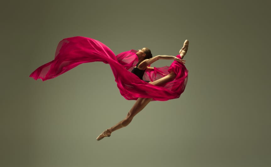 A ballet dancer with a pink silk cloth swirling around her.