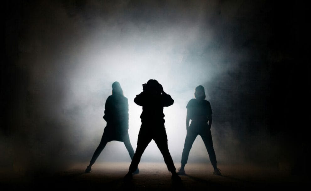  A silhouette of three dancers with a backlight.