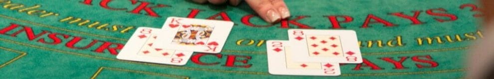 Two blackjack hands are dealt on a casino table.