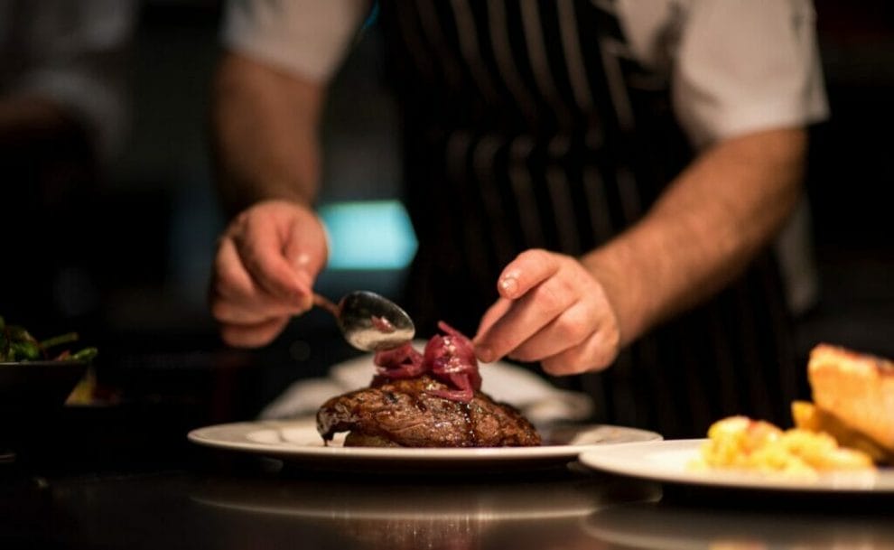 A chef plating a steak.