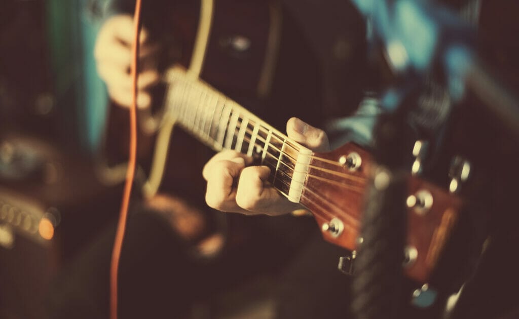 A close-up of someone playing a guitar.