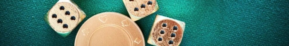 Gold casino chips and dice on a green felt table.