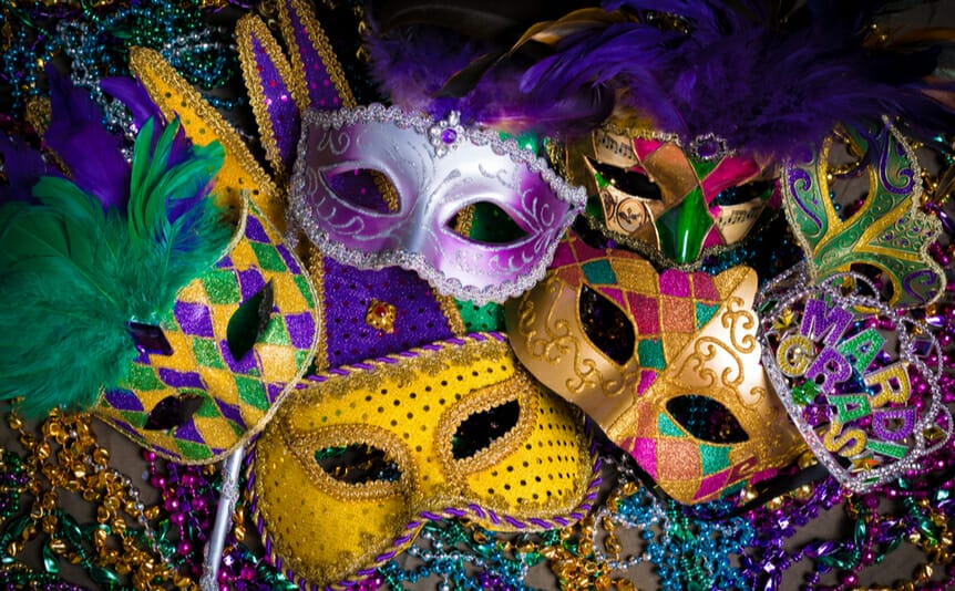Colorful carnival masks with a lilac mask in the foreground.