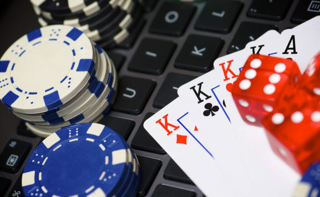 Casino chips, playing cards and dice on top of a keyboard