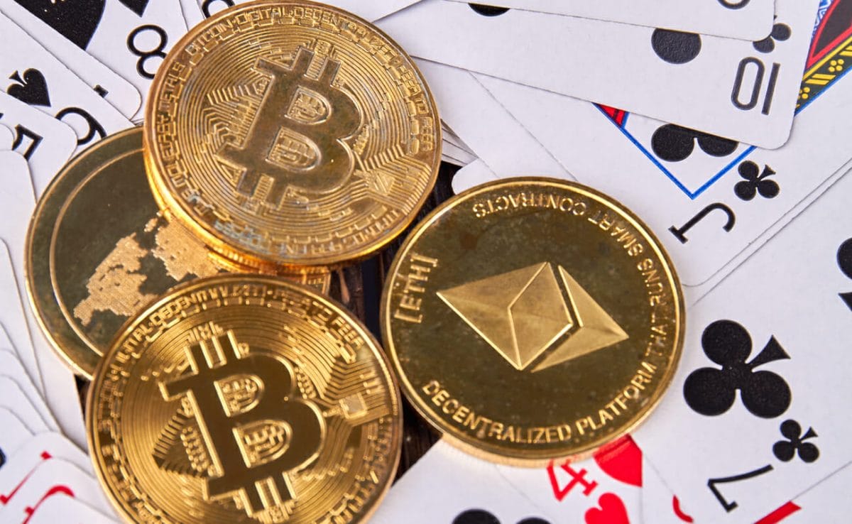 Some cryptocurrency coins on top of playing cards.