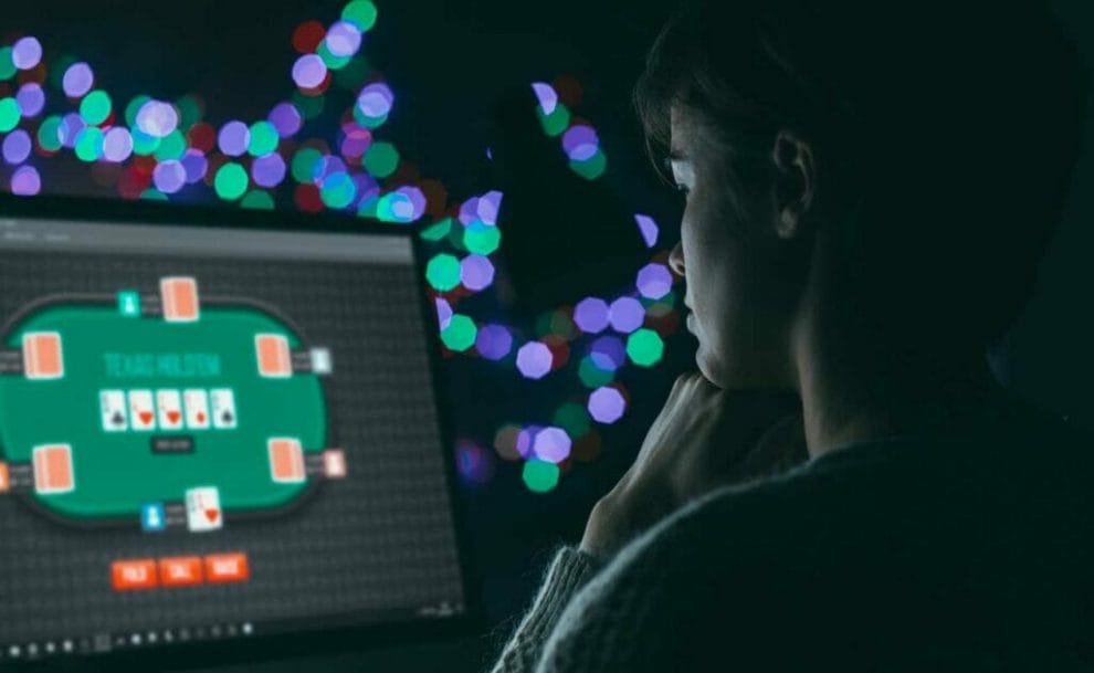 A woman plays online poker on a desktop computer.