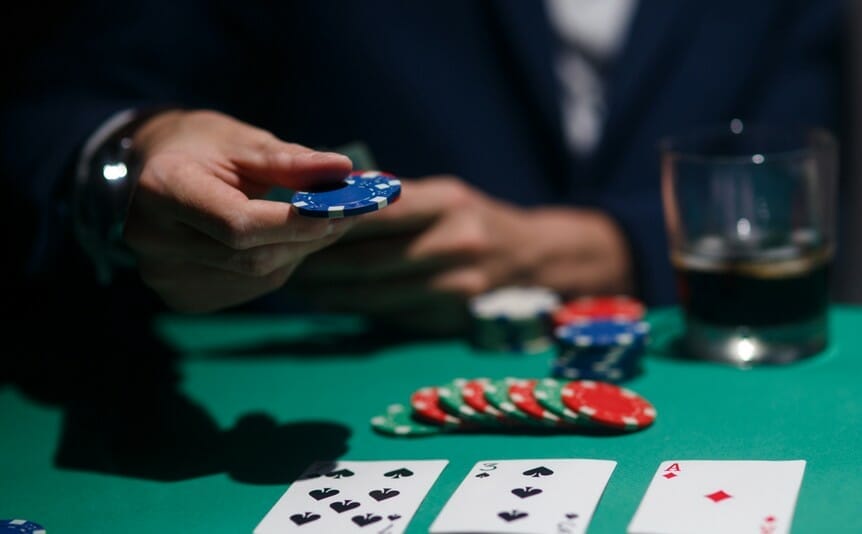 A poker player adds his chips to the pot.