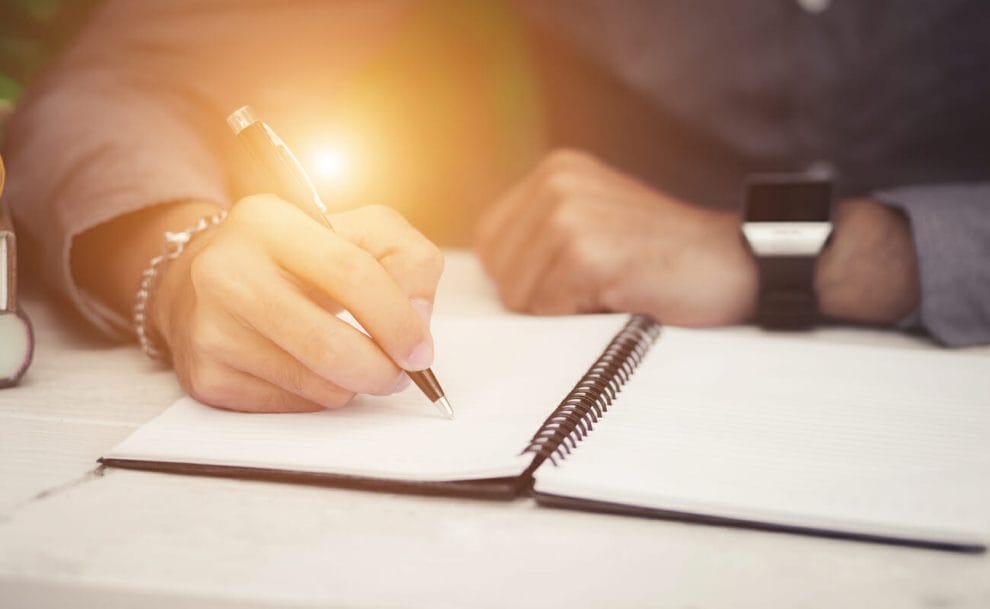 A man sitting at his desk, journaling.