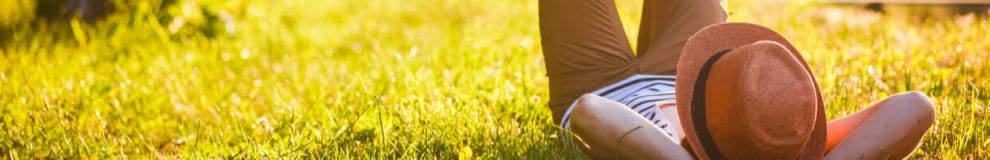 A person relaxing on some grass in the sun.