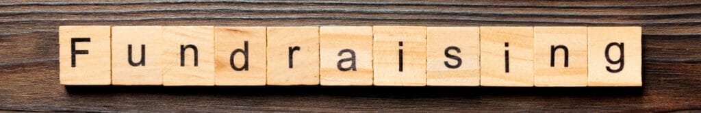 The word “Fundraising” written on wooden blocks.