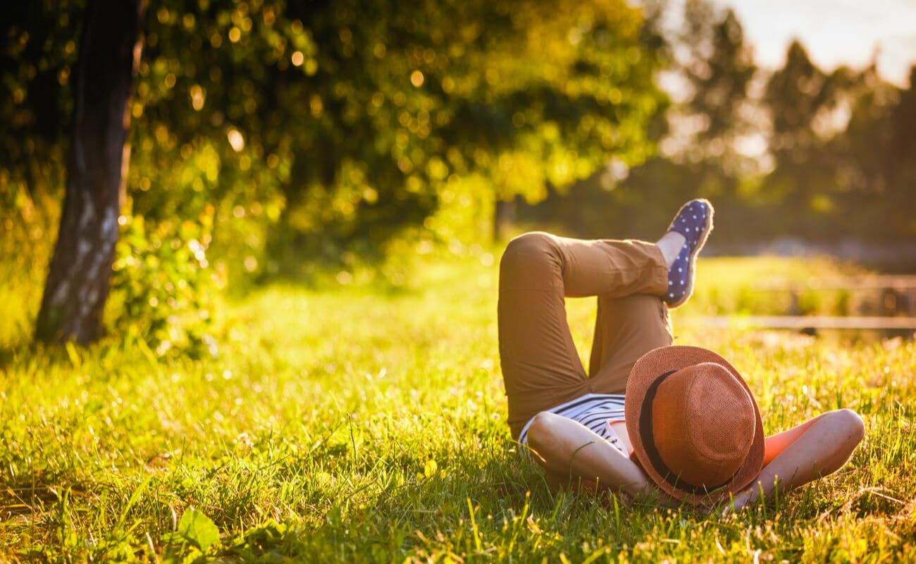 A person relaxing on some grass in the sun.
