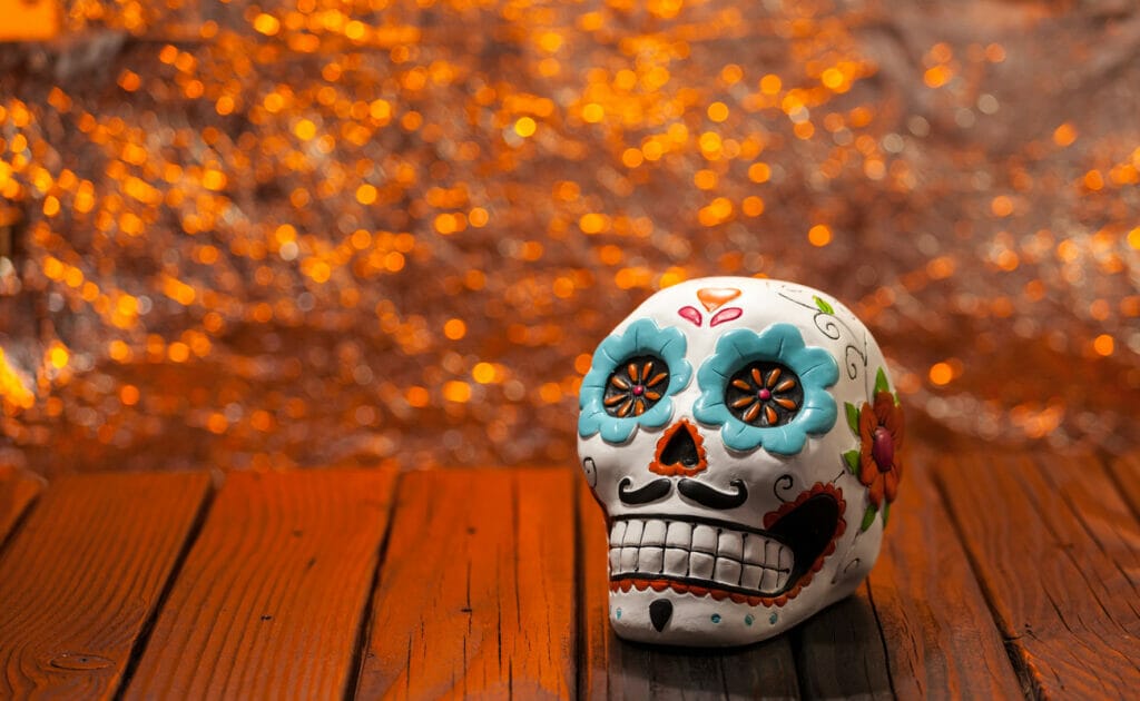 A skull painted in a Day of the Dead theme on a porch.