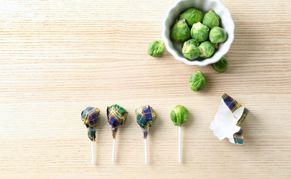 Brussel sprouts being wrapped and disguised as lollipops.