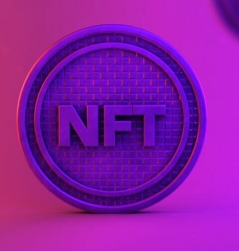 The letters NFT printed on a virtual coin.